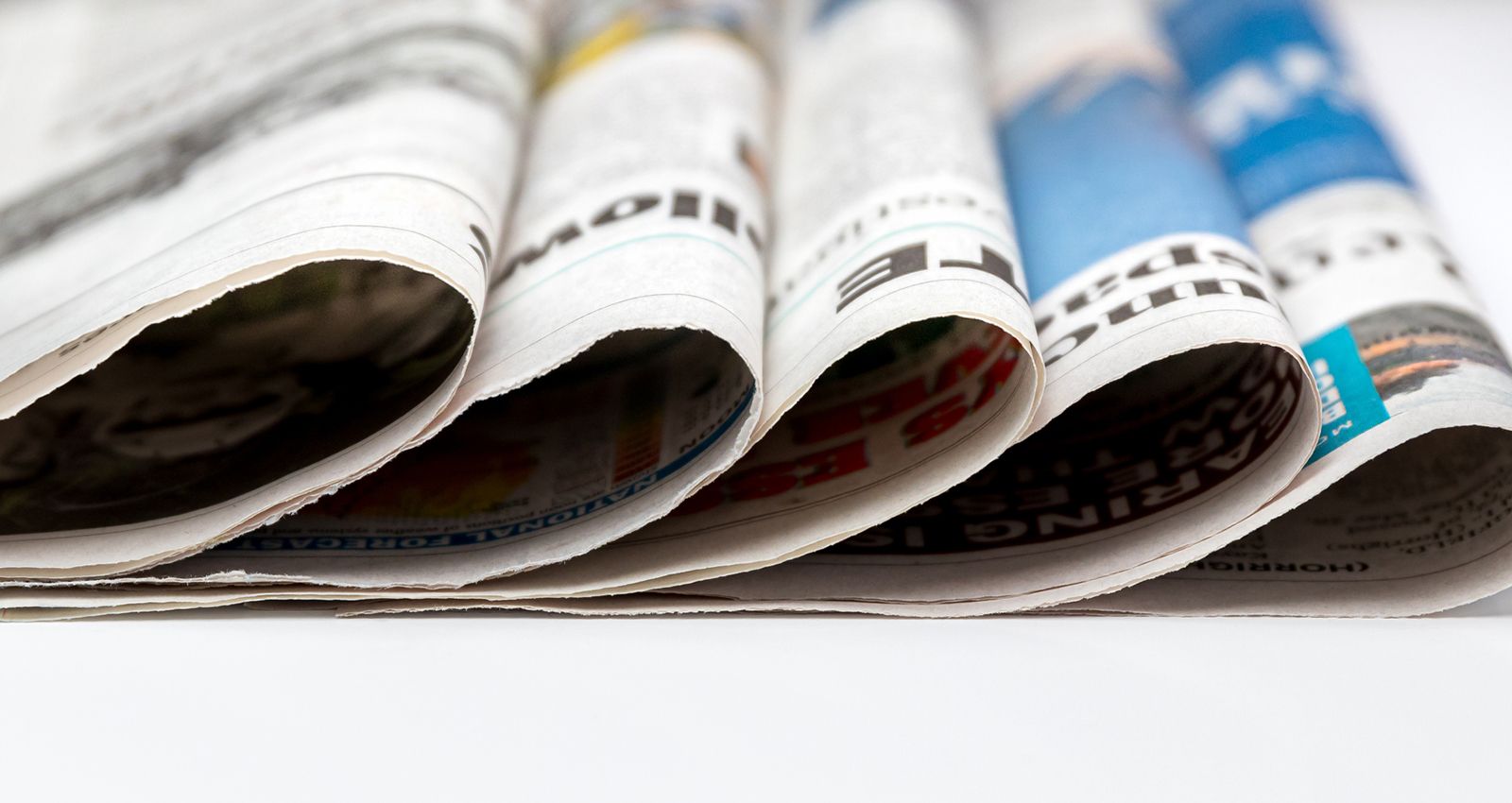 A stack of newspapers piled on a table
