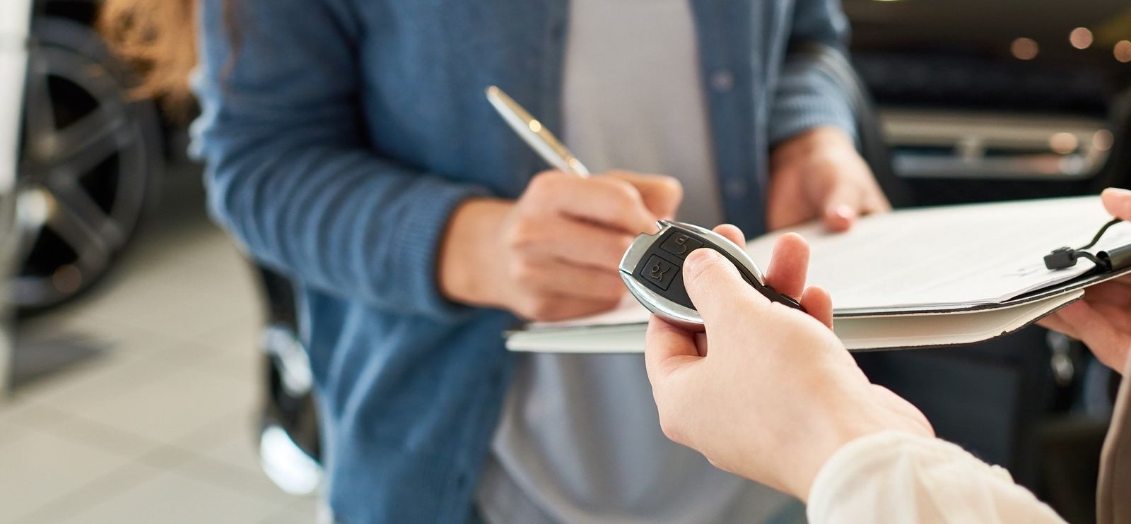 A customer filling out paperwork to buy a car