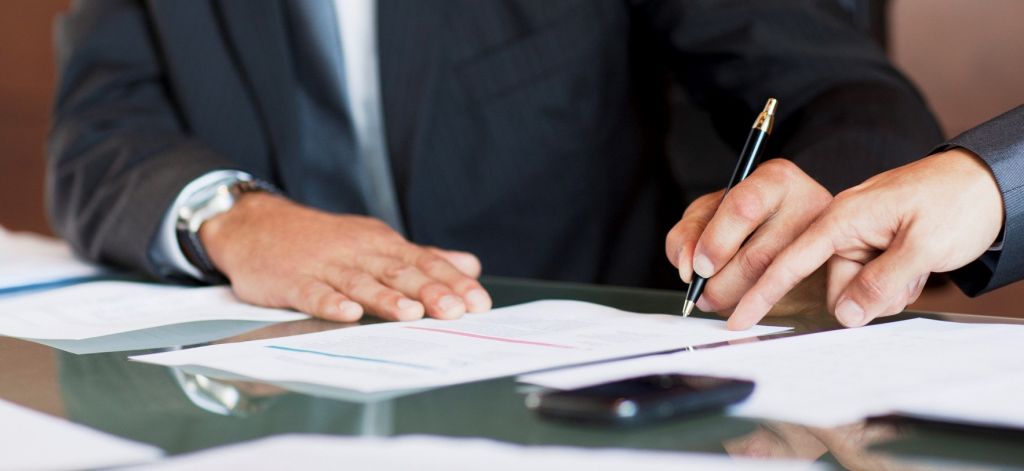 Businessmen signing paperwork