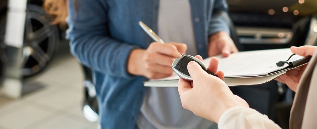 A customer filling out paperwork to buy a car