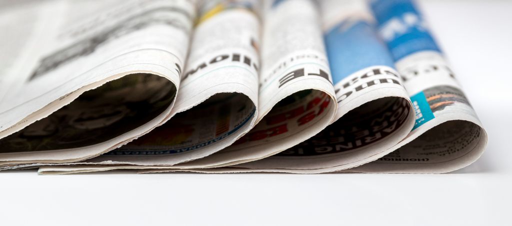 A stack of newspapers piled on a table