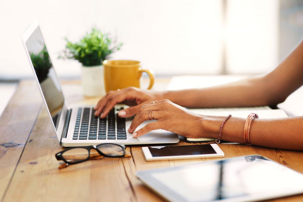 Woman using laptop next to coffee cup