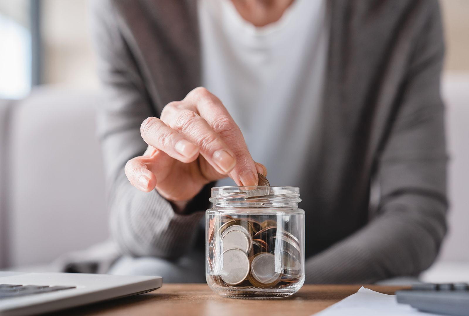 Woman adding coins to a jar
