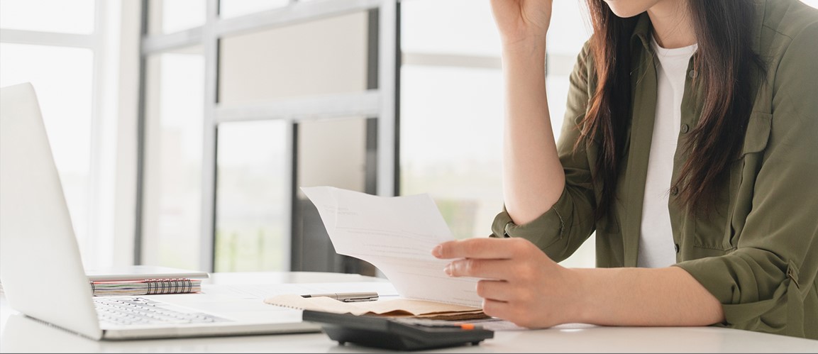 Woman with a calculator holding a piece of paper