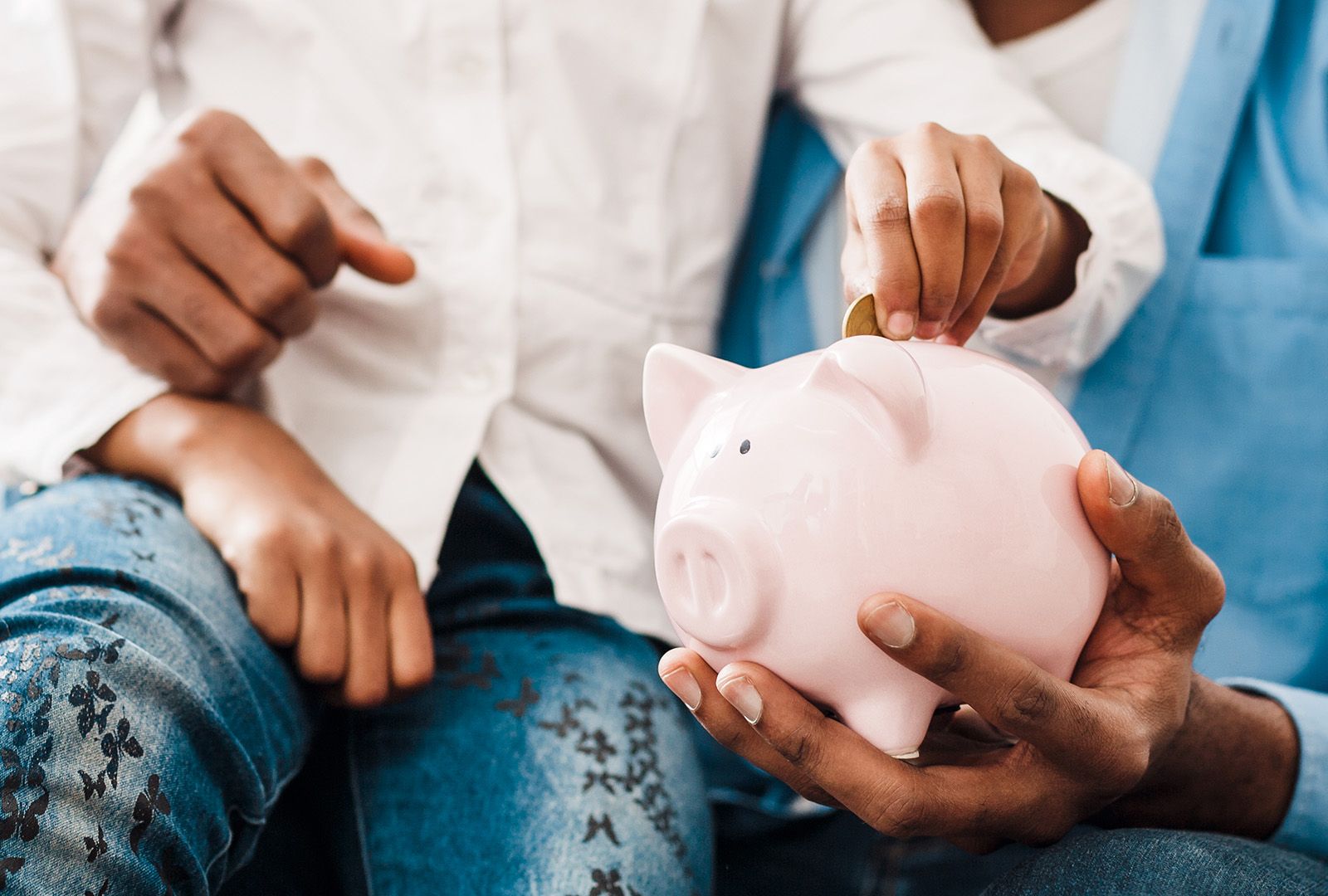 child putting coins into a piggy bank