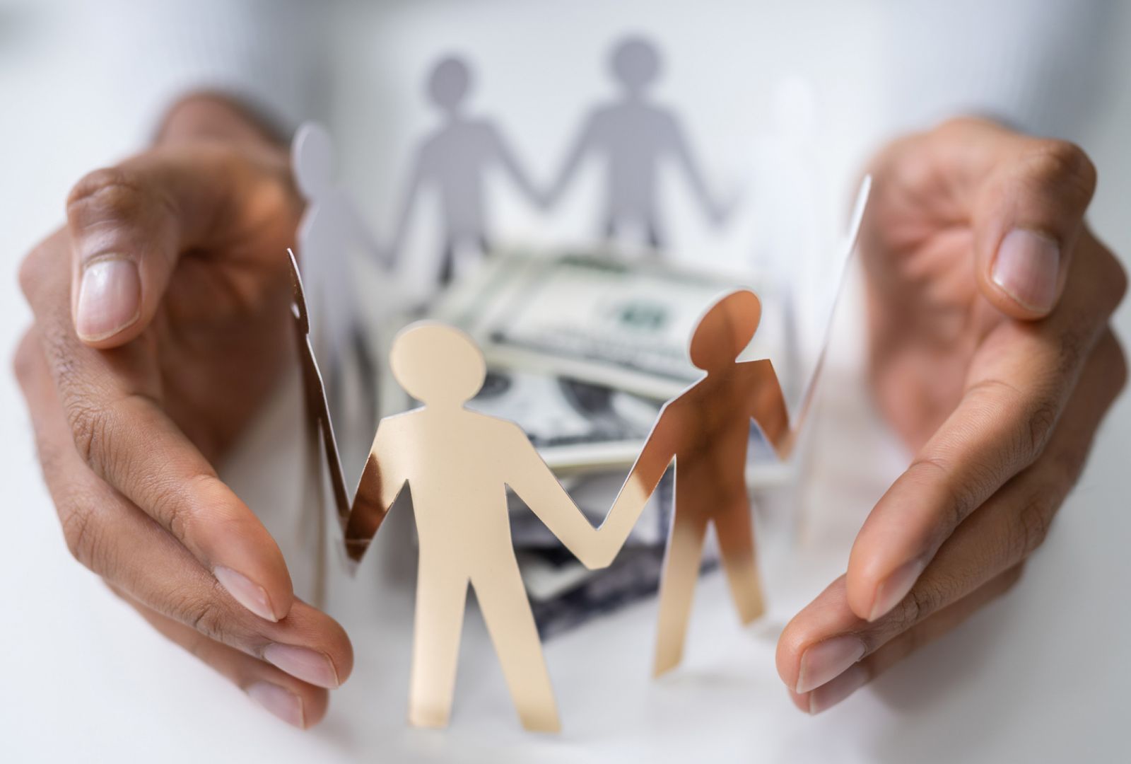 Hands holding a circle of community members with money in the middle
